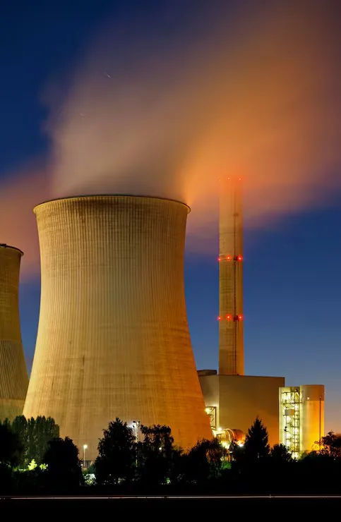 Tour de refroidissement dâune centrale nuclĂ©aire Ă©clairĂ©e Ă la tombĂ©e de la nuit